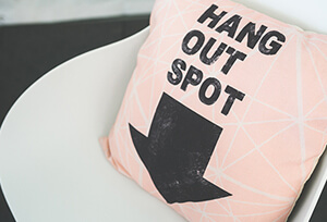 На стуле подушечка с надписью и жирной стрелкой вниз